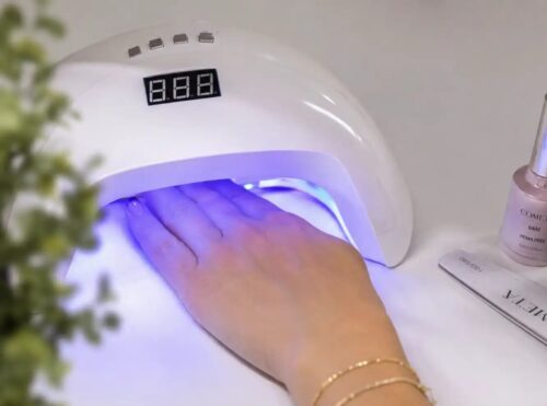 Mano durante la polimerizzazione del gel in lampada UV/LED per spiegare perché il gel può sviluppare più calore in estate e come ridurre il fastidio.