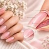 Manicure rosa con illustrazione anatomica della struttura dell'unghia, della lamina e del letto ungueale.